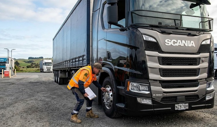 Truck driver completing a pre-journey inspection on a Scania heavy vehicle